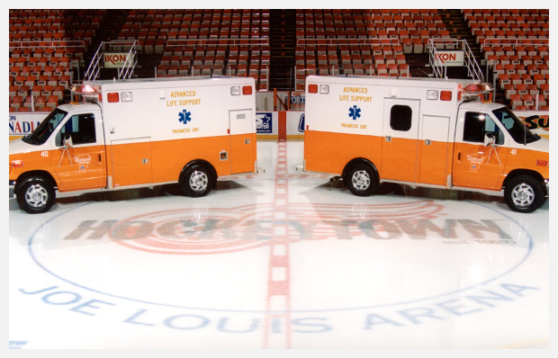 Two ambulances parked on an ice rink in Joe Louis Arena