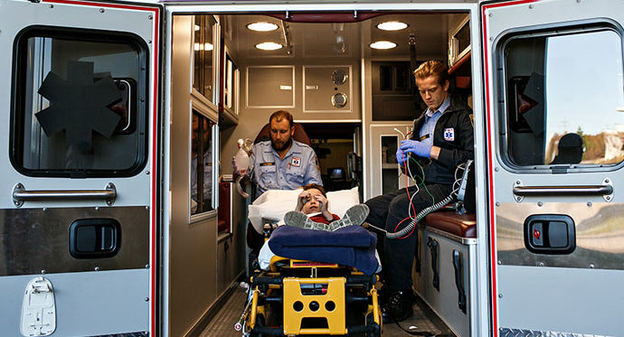 First responders inside an ambulance with a child on a stretcher